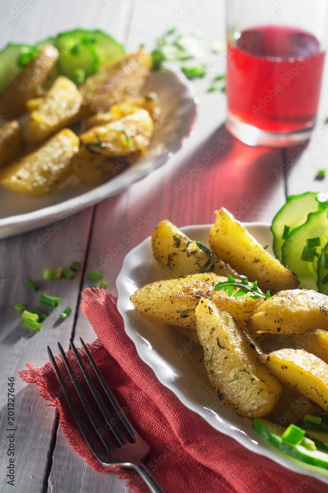 Fried potatoes with spices and fresh cucumber and juice