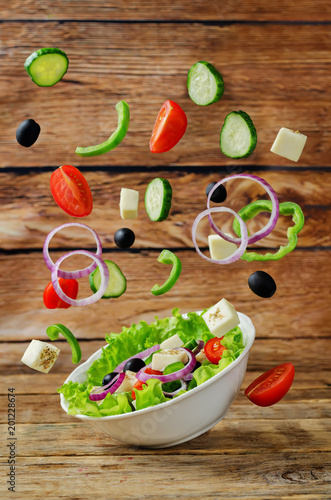 Greek Salad with flying ingredients to prepare it