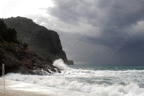 Big waves crushing on curved stone, on stormy weather, big tide. Alanya, Turkey.