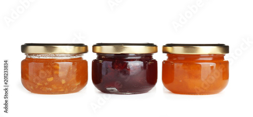 Three jars with tasty sweet jam on white background