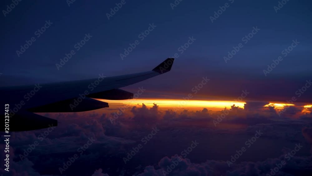COPY SPACE POV: Large airplane wing flying through beautiful purple and orange sky. Commercial plane flying at cruising altitude passes colorful twilight. Cool view from the window seat of an airplane COPY SPACE POV: Large airplane wing flying through beautiful purple and orange sky. Commercial plane flying at cruising altitude passes colorful twilight. Cool view from the window seat of an airplane