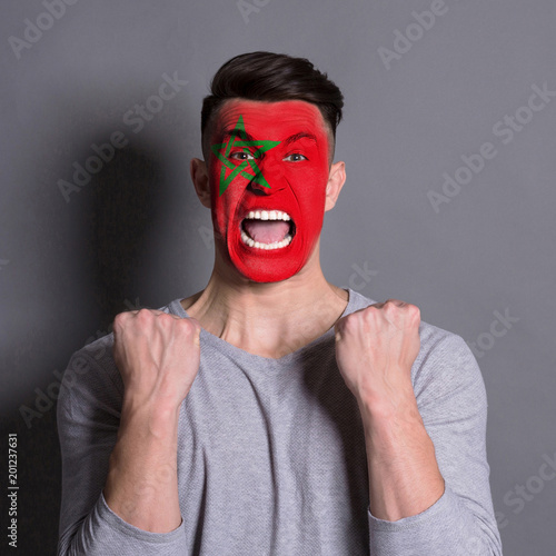 Young man with Morocco flag painted on his face