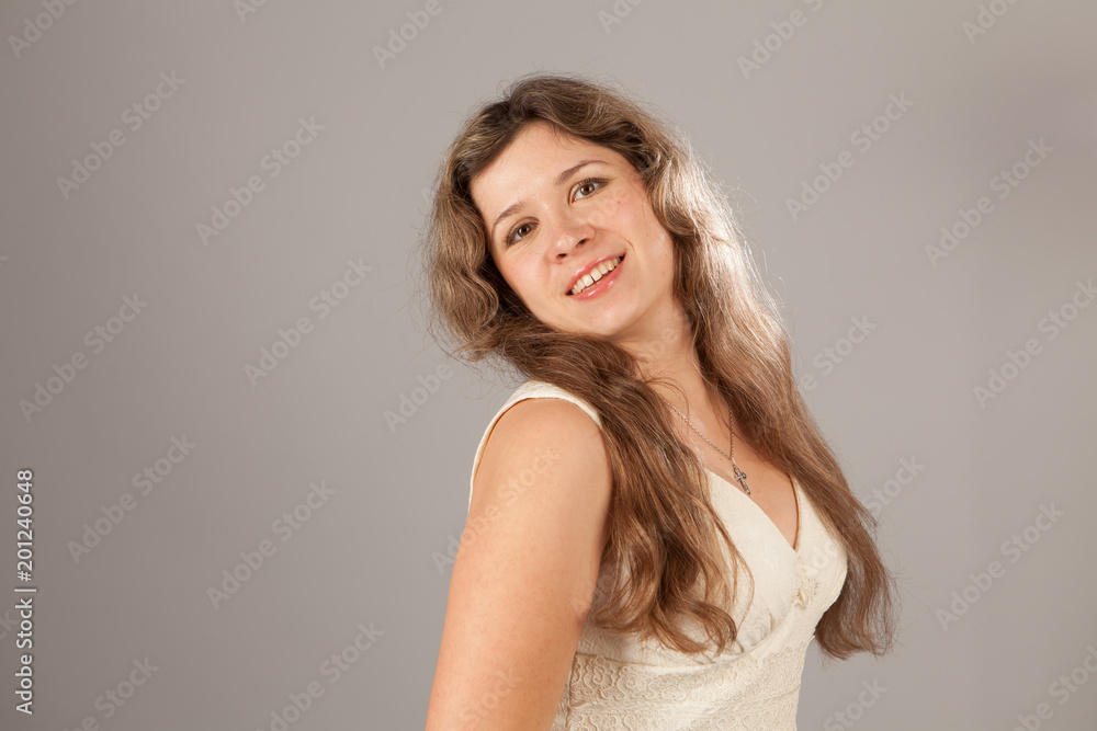 Fashion photo of a young charming woman with curly hair wearing white dress Fashion photo of a young charming woman with curly hair wearing white dress
