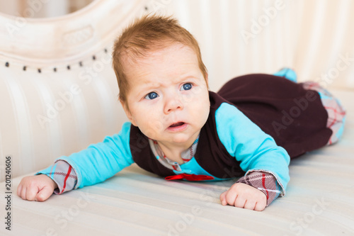 Baby boy lying on a sofa in sunny room