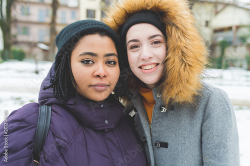 portrait two young beautiful women outdoor looking camera smiling - happiness, positive feelings, customer concept