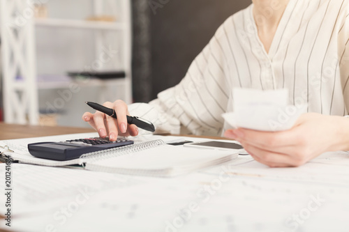 Closeup of woman hands counting on calculator