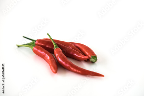 Group of red hot chili peppers isolated on the white background. Selective focus.