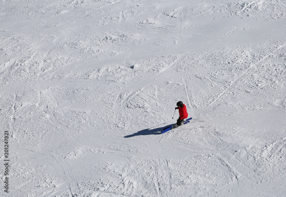 skier in a red suit while descending on the ski slope skier in a red suit while descending on the ski slope