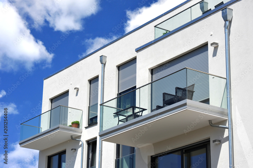 Moderne Balkone, verglast mit Metall-Geländer an Neubau-Hausfront mit  Flachdach, Wasserkästen, Regenfallrohren und Edelstahl-Attika Stock-Foto |  Adobe Stock