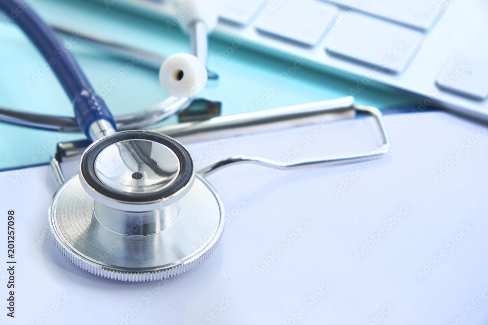Stethoscope with clipboard and Laptop on desk,Doctor working in hospital writing a prescription. Healthcare and medical concept, test results in background, selective focus Stethoscope with clipboard and Laptop on desk,Doctor working in hospital writing a prescription. Healthcare and medical concept, test results in background, selective focus