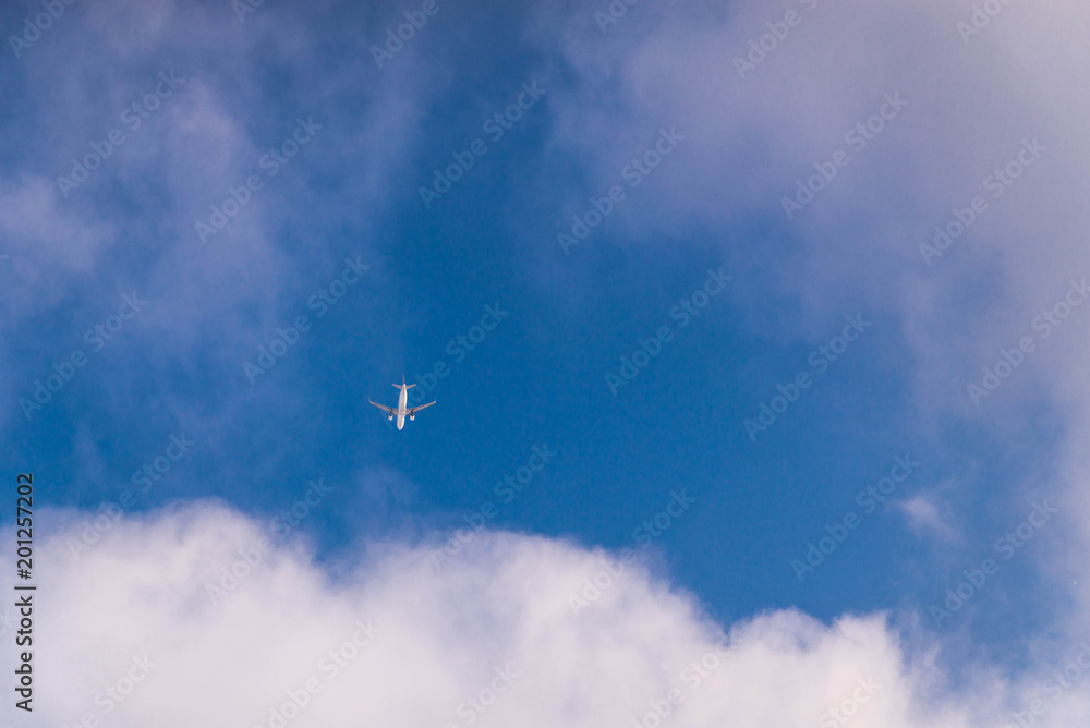 view of plane from ground. travel concept. blue sky with white clouds