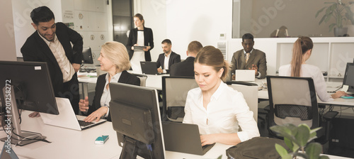 Business people working in open plan office photo