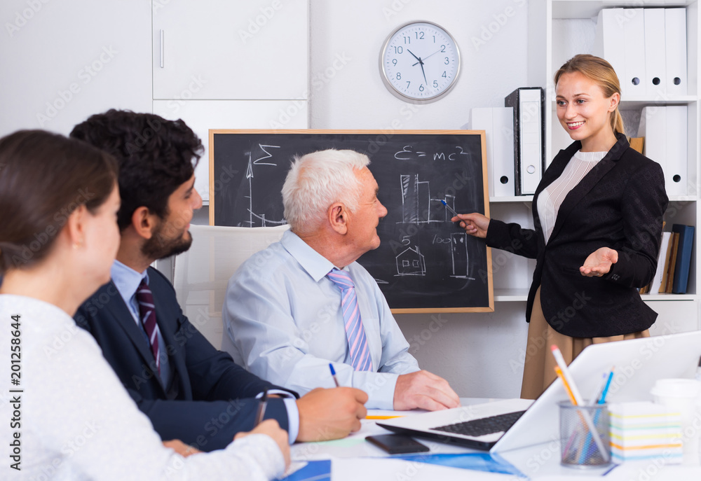 Fototapeta premium Manager female is reading financial report to colleagues on meeting