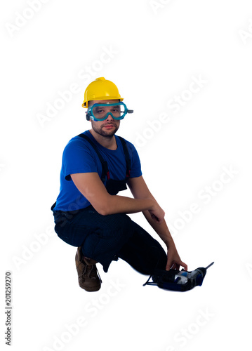 Handsome workman kneeling on white background photo