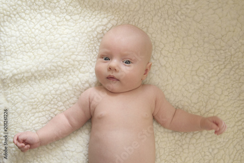 Portrait of a cute newborn child against a white sheepskin