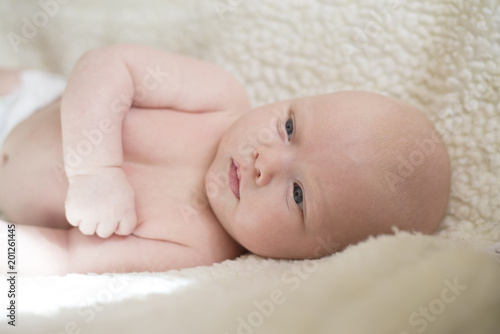 Portrait of a newborn baby lying on his side