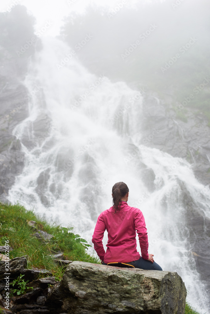 Φωτογραφία Tourist girl relaxing on rock and enjoying beautiful view of waterfall Balea in Fagarash mountains