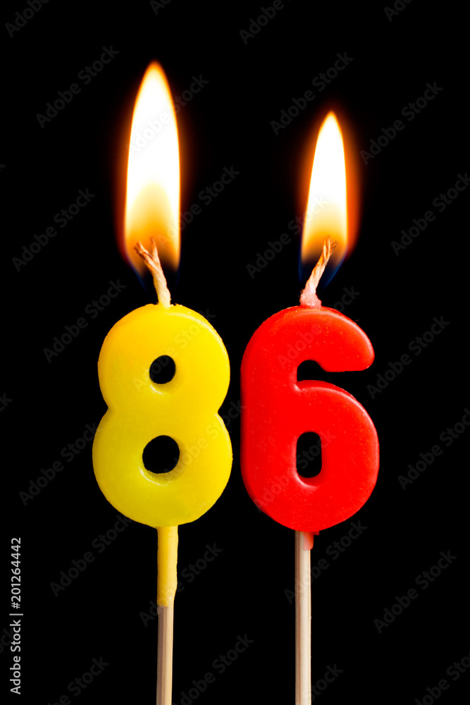 Burning candles in the form of 86 eighty six (numbers, dates) for cake isolated on black background. The concept of celebrating a birthday, anniversary, important date, holiday, table setting Burning candles in the form of 86 eighty six (numbers, dates) for cake isolated on black background. The concept of celebrating a birthday, anniversary, important date, holiday, table setting