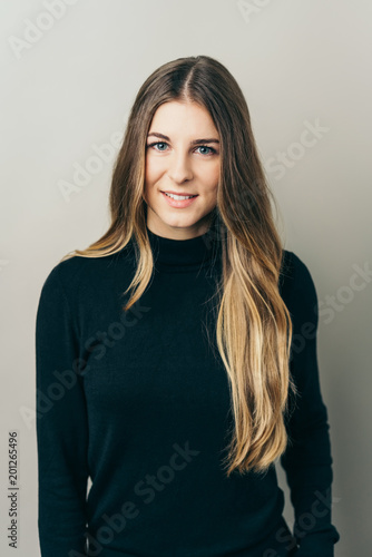 Smiling long-haired woman against plain background