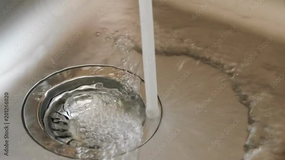 Water from a tap fills a kitchen sink. Water from a tap fills a kitchen sink.