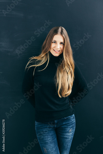 Young cheerful woman against black background