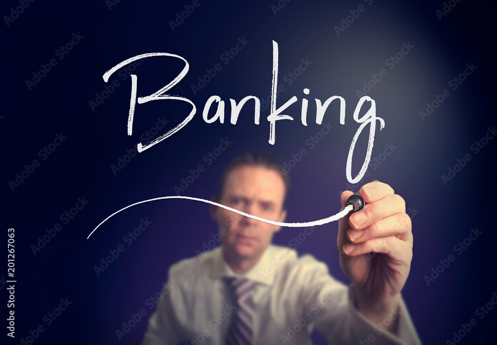A businessman writing a Banking concept with a white pen on a clear screen. A businessman writing a Banking concept with a white pen on a clear screen.