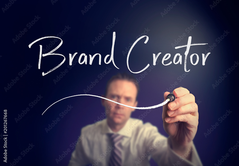 A businessman writing a Brand Creator concept with a white pen on a clear screen. A businessman writing a Brand Creator concept with a white pen on a clear screen.