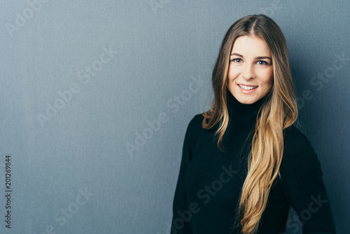 Young smiling woman against blue background photo