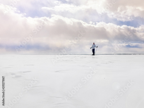 Girl on skis in the field on a blue sky background