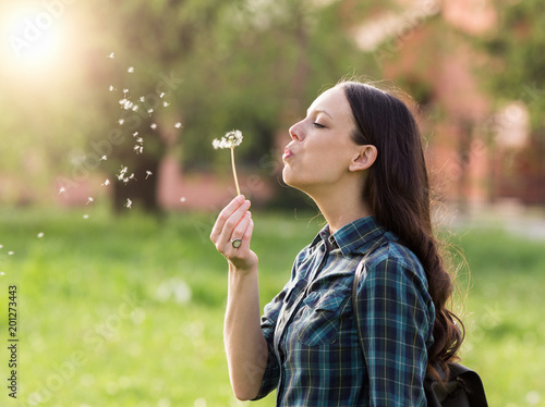 Woman blowing dandelion flower