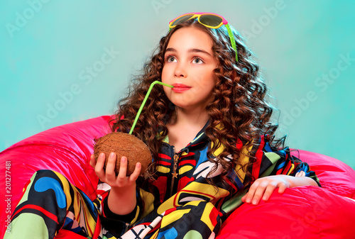 летний портрет красивой девочки с улыбкой на отдыхе под пальмой с кокосом