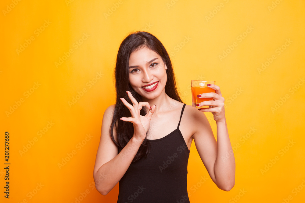 Asian woman with a clock drink orange juice. Asian woman with a clock drink orange juice.