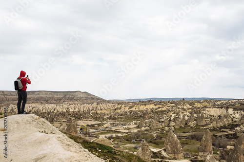 traveler in a red sweatshirt looks at the landscape of Cappadocia
