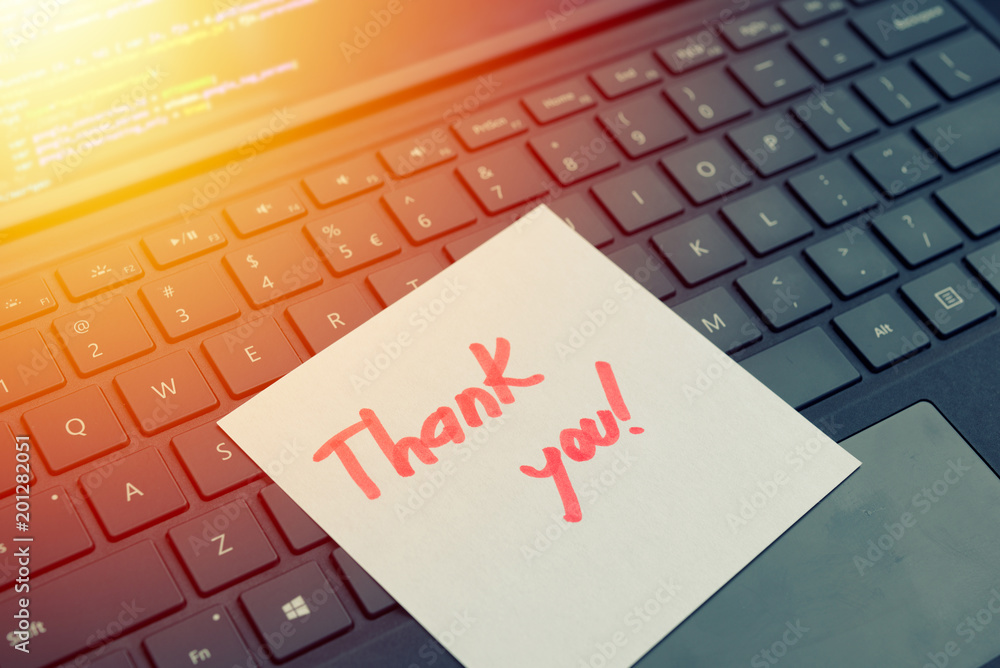 Thank you message concept written post it on laptop keyboard Thank you message concept written post it on laptop keyboard
