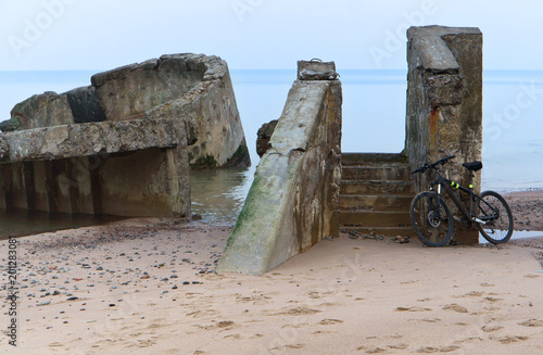 Bicycling along the wild coast. The ruins of ancient buildings on the shore.
