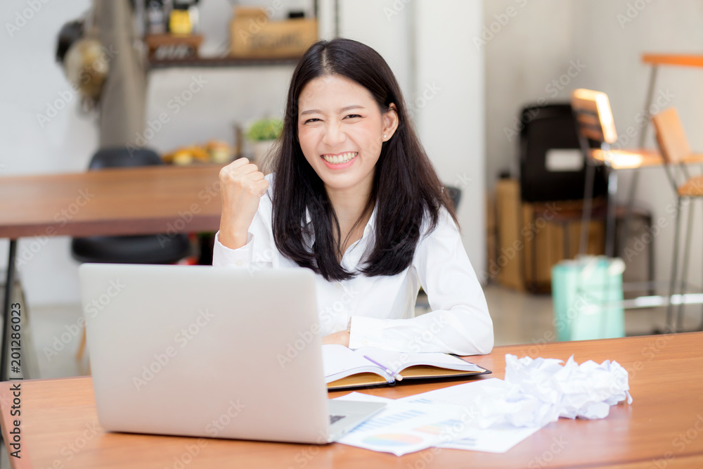 Beautiful asian young woman working online on laptop sitting at coffee shop, professional female freelancer with paper crumpled and using notebook computer with connect to internet for distance job. Beautiful asian young woman working online on laptop sitting at coffee shop, professional female freelancer with paper crumpled and using notebook computer with connect to internet for distance job.