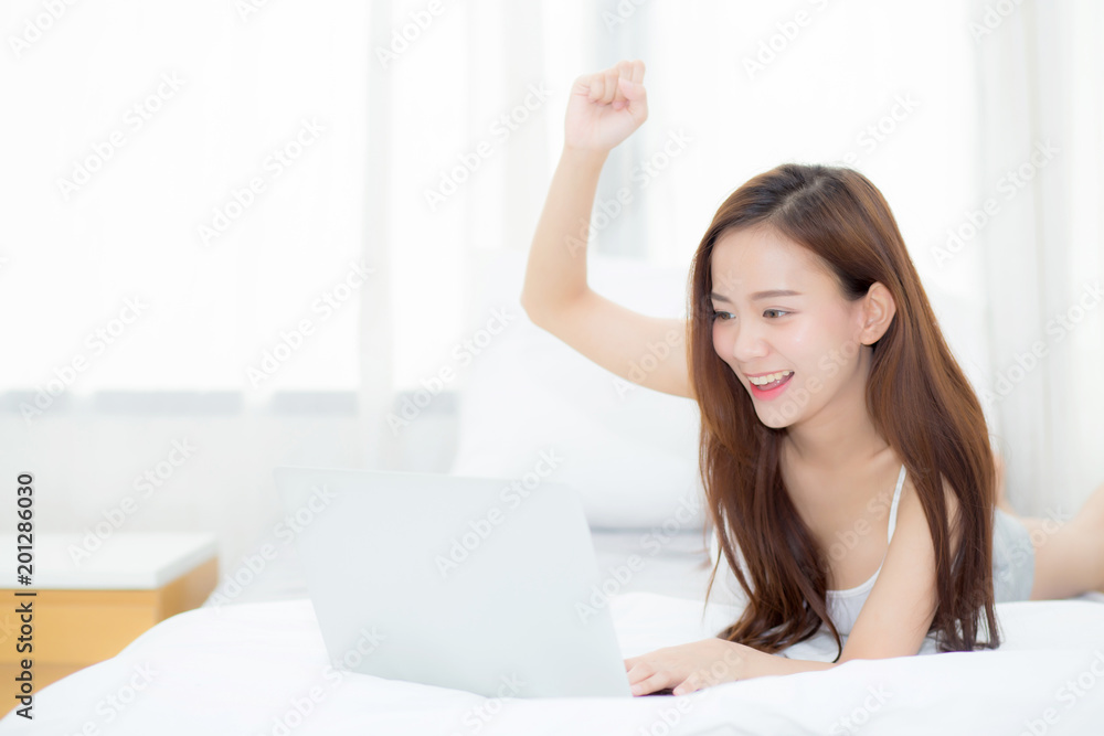 Beautiful asian young woman relax and leisure with laptop internet online on vacation in bedroom, cheerful of asia girl with gesture glad and success, lifestyle concept. Beautiful asian young woman relax and leisure with laptop internet online on vacation in bedroom, cheerful of asia girl with gesture glad and success, lifestyle concept.