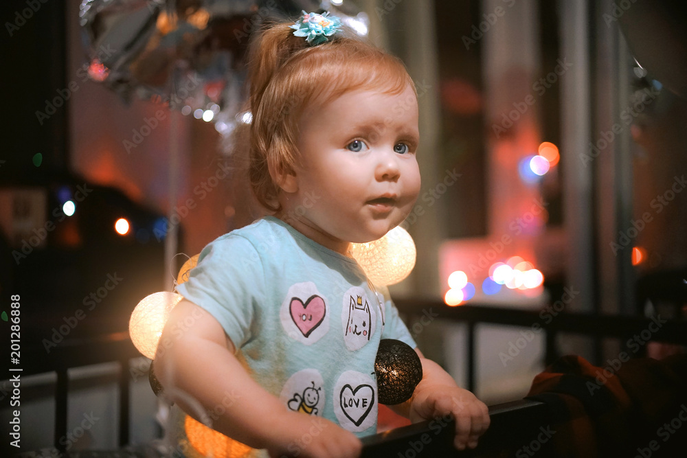 Cute child standing in the bed and playing with Christmas lights Cute child standing in the bed and playing with Christmas lights