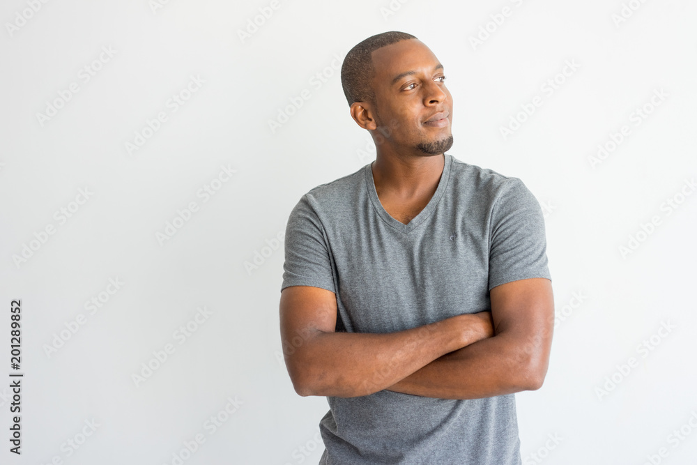 Pensive dreamy young African man with crossed arms looking away.  Introspective handsome guy in t-shirt thinking. Inspiration concept Stock  Photo | Adobe Stock
