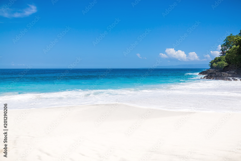 Tropical white sand beach and blue ocean with crystal water in Bali