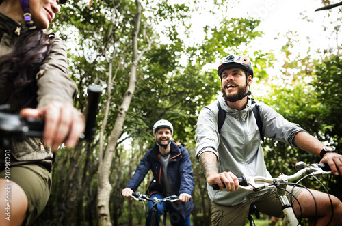 Group of friends ride mountain bike in the forest together