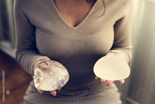 Woman holding silicon bags for breast implant photo