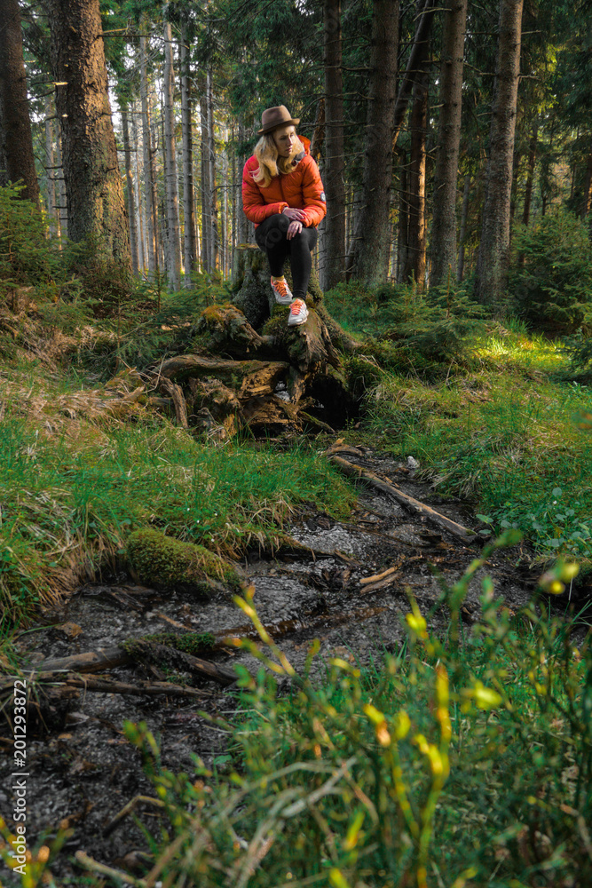 Naklejka premium caucasian female hiker standing on a dirt road with big backpack