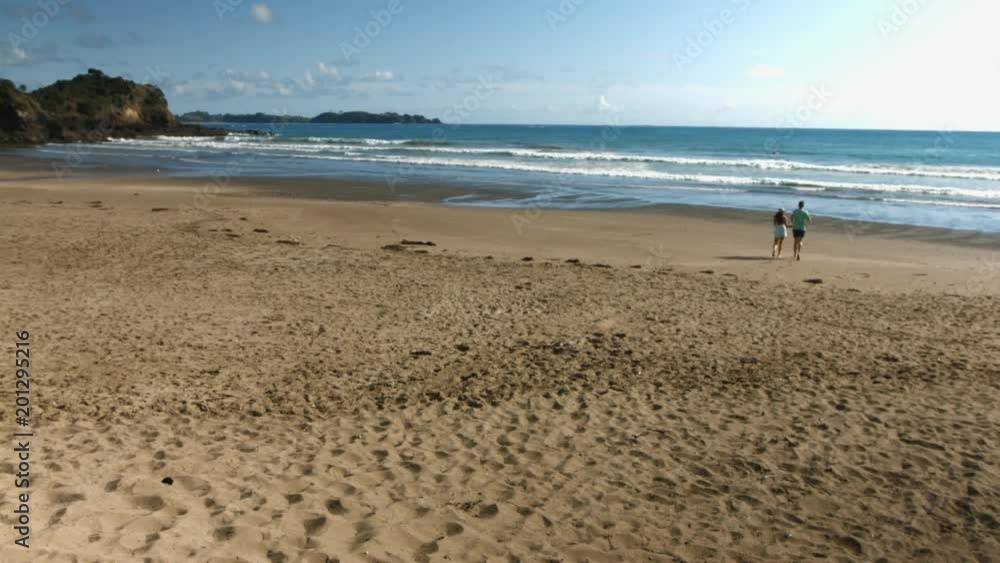Couple running on beach towards the ocean. Couple running on beach towards the ocean.