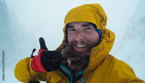 winter alpine misery, mountaineer taking a selfie in a bad weather in a winter mountains