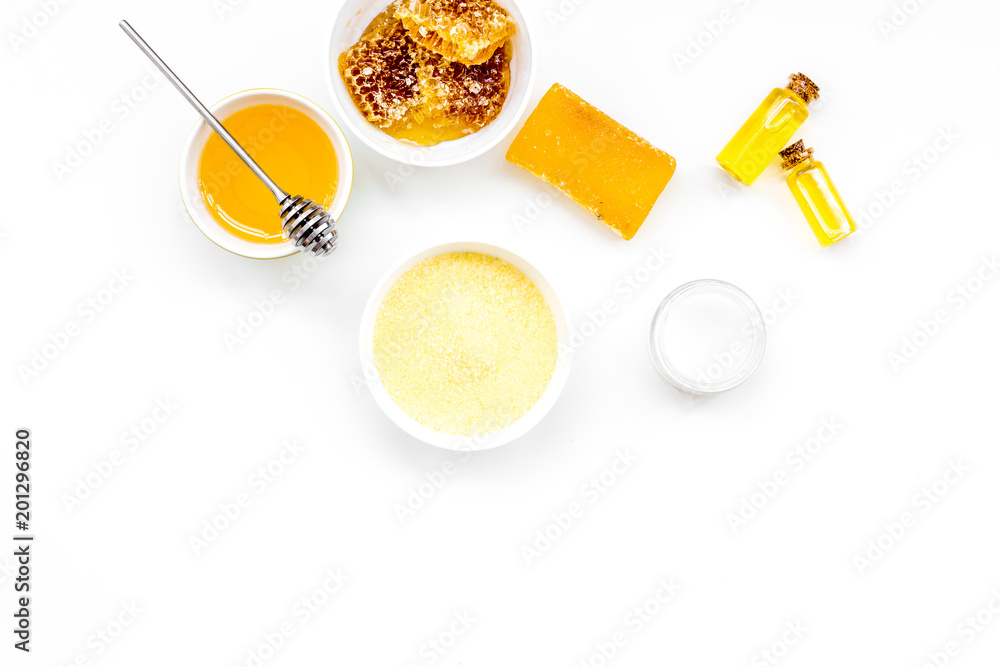 Homemade cosmetics with honey. Handmade soap, spa salt, cream on white background top view Homemade cosmetics with honey. Handmade soap, spa salt, cream on white background top view