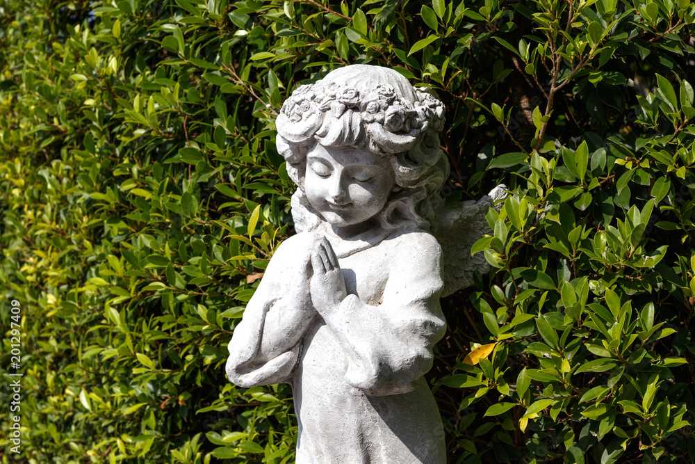 Statues of Guardian angels in green garden Statues of Guardian angels in green garden