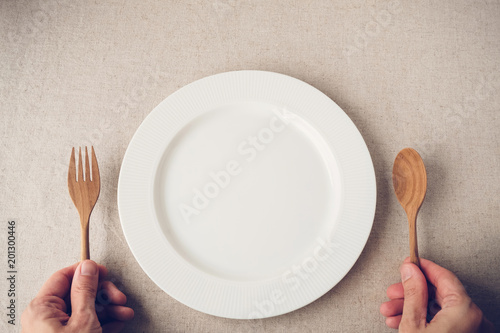 white plate with spoon and fork, Intermittent fasting concept, ketogenic diet, weight loss, diet, restaurant cafe reopening again soon post covid-19 coronavirus pandemic, food crisis photo