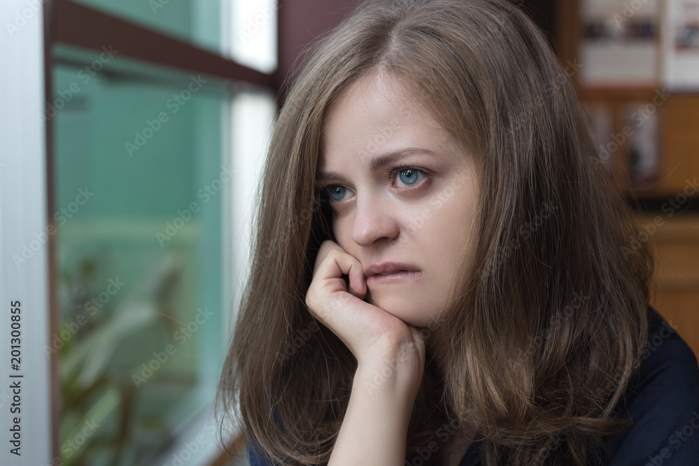 Young caucasian woman looking away, out of window, looks depressed, sad, upset and unhappy Young caucasian woman looking away, out of window, looks depressed, sad, upset and unhappy