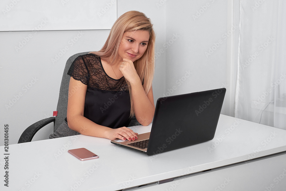 Beautiful business woman is working behind laptop at office Beautiful business woman is working behind laptop at office